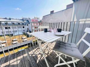 een witte tafel en stoelen op een balkon bij Designer flat to feel good in in Wenen