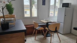 ボルドーにあるBed To Rent - Maison Calme avec Jacuzzi sous Supplémentのキッチン(テーブル、椅子、冷蔵庫付)