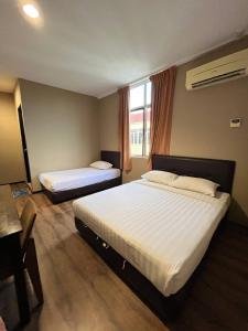 a hotel room with two beds and a table at M BOUTIQUE INN (PERMYJAYA) in Miri