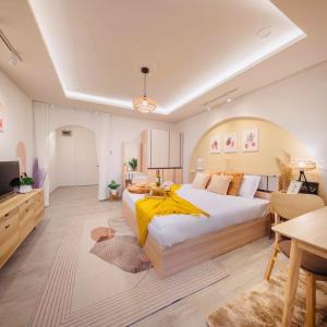 - une chambre avec un grand lit et une couverture jaune dans l'établissement Srithana Condominium Cozy Room, à Chiang Mai