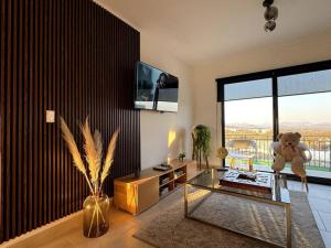 a living room with a glass table and a teddy bear at Depto lujo Querétaro climatizado in Querétaro