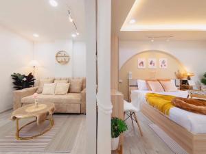 - une chambre avec un lit et un canapé dans l'établissement Srithana Condominium Cozy Room, à Chiang Mai