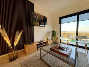 a living room with a glass table and a large window at Depto lujo Querétaro climatizado in Querétaro