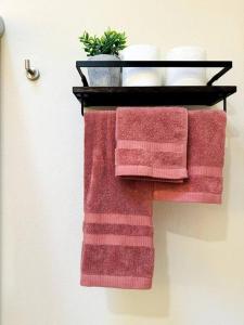 um toalheiro com duas toalhas vermelhas e uma planta em Depto lujo Querétaro climatizado em Querétaro