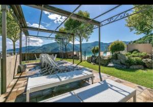 a patio with a bench and a view of the ocean at Appartement Magliolo Ligurie / Piscine - SPA - Vue in Magliolo