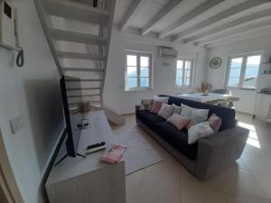 a living room with a couch and a table at Appartement Magliolo Ligurie / Piscine - SPA - Vue in Magliolo
