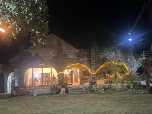 a house at night with lights in the window at Kadilian Beach House in Currimao