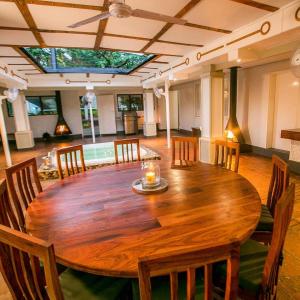 a large wooden table with chairs and a candle on top at A wonderful 5 bedroomed 4 bathroom Villa with swimming pool gym garden of the highest quality - 2215 in Victoria Falls