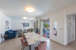 a dining room and living room with a table and chairs at Napa Sunlight Villa #2 in Ayia Napa