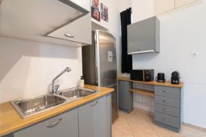 een keuken met een spoelbak en een koelkast bij Neoclassical Loft in Monastiraki - Acropolis and metro in Athene +8 foto's