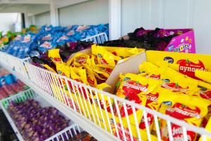 a store shelf filled with bags of chips and other snacks at SleepOver Punda Maria Gate in Thohoyandou