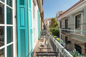 een balkon in een stad met tafels en stoelen bij Neoclassical Loft in Monastiraki - Acropolis and metro in Athene