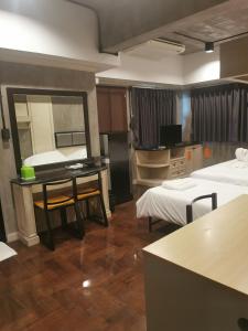 バンコクにあるbangkok bed placeのベッド2台、テーブル、鏡が備わる客室です。