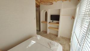 uma casa de banho branca com uma banheira e uma televisão em The Roof Ada em Adalar