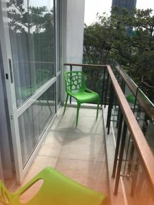 a balcony with a green chair and a window at Crown Properties in Colombo