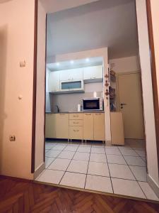 cocina con armarios blancos y suelo de baldosa en Apartment Babin do en Budva