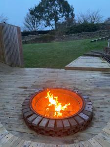 a fire pit in the middle of a patio at Winnie Cottage - Hot Tub, Games Room, Sauna, Large Garden in Stocksfield