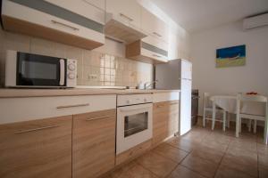 een keuken met houten kasten en een magnetron bij Apartments Betty in Rovinj