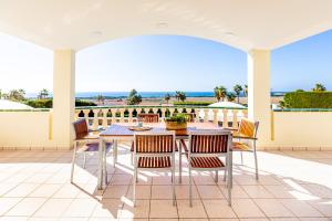 - une table et des chaises sur une terrasse avec vue sur l'océan dans l'établissement Villa Terra, à Son Bou