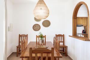 uma sala de jantar com uma mesa de madeira e cadeiras em Villa Terra em Son Bou