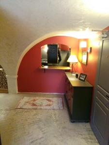 a room with a red wall with a desk and a microwave at le Mas du lac - spa et détente in Monestier-dʼAmbel