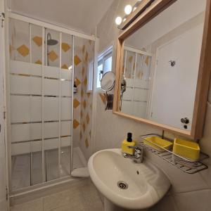 a bathroom with a sink and a shower and a mirror at Bea's Bed & Breakfast in Tavira