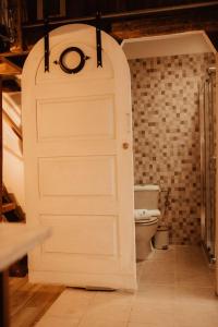 - Puerta blanca en el baño con aseo en The Caravel Apúlia, en Apúlia