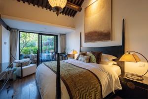 a bedroom with a bed and a large window at Beijing Le Zai Nan Luo Gu Xiang Wang Fu Jing Forbidden City Courtyard Hotel in Beijing