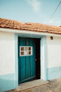 a blue door of a house with a window at The Caravel Apúlia in Apúlia