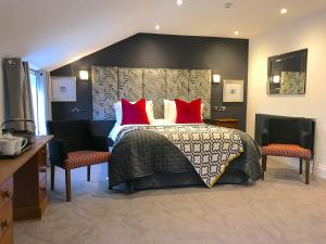 a bedroom with a large bed with red pillows at The Helaina in Scarborough