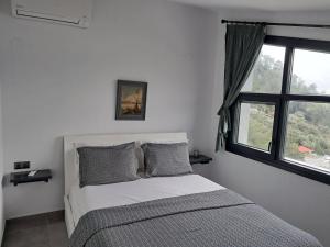 - une chambre blanche avec un lit et une fenêtre dans l'établissement Waterview Villa, à Chrysi Ammoudia