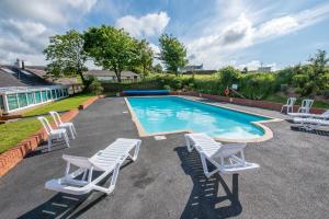 a group of chairs and a swimming pool at Lakeside Cottage in Woolacombe