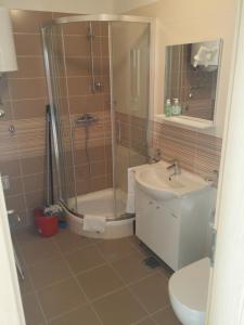 La salle de bains est pourvue d'une douche, d'un lavabo et de toilettes. dans l'établissement Apartments Rtina Benici, à Rtina