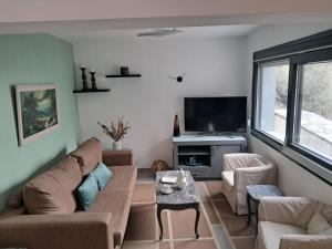 - un salon avec un canapé et une télévision dans l'établissement Waterview Villa, à Chrysi Ammoudia