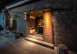 北京Beijing Le Zai Nan Luo Gu Xiang Wang Fu Jing Forbidden City Courtyard Hotel&Free laundry service&Free coffee &Paid Dumpling experience service的砖砌建筑,有一扇开门,种植植物