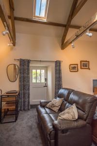 a living room with a leather couch and a window at Wydon Farm Bed and Breakfast in Haltwhistle