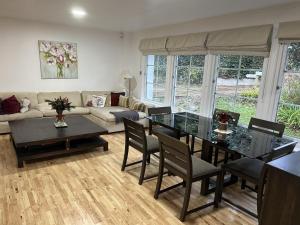 a living room with a table and a couch at 3 Bed House - Sleeps 5 - Sauna - Garden - Gym in Kingston upon Thames