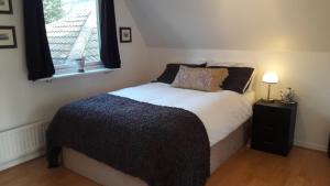 a bedroom with a large bed with a window at Large 3 bed house with separately bookable studio in Kingston upon Thames