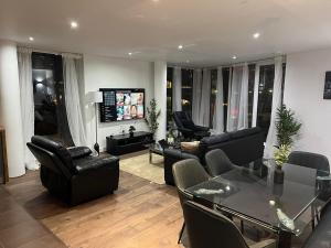 a living room with black furniture and a television at Luxury Dockview 3 Beds Excel London in London
