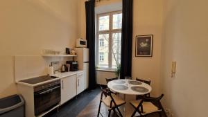 una cucina con tavolo e tavolino con sedie di Center High Apartment CityBeat#1 a Cracovia