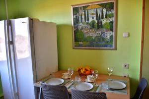 Comfortable 4-Room Apartments in Jekabpils في جيكاببيلس: طاولة طعام مع كراسي و لوحة على الحائط