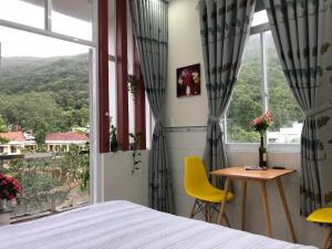 1 dormitorio con cama, mesa y ventana en Sunny Homestay Quy Nhơn en Quy Nhon