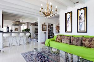 een woonkamer met een groene bank en een keuken bij B&B RED WINE COUNTRY HOUSE in Castel San Pietro Terme
