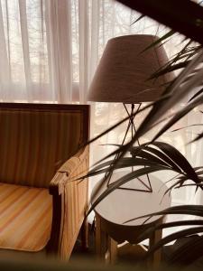 une lampe assise à côté d'une chaise et d'une fenêtre dans l'établissement City Solei Boutique Hotel, à Poznań