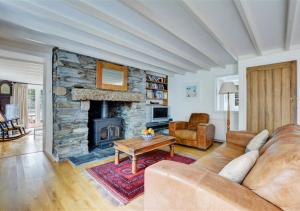 a living room with a couch and a stone fireplace at Clovertown in Saint Veep