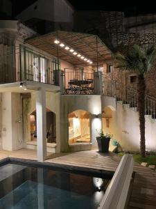 ヴァルレアスにあるDrome provençale maison familiale calme dans villageのスイミングプールとバルコニー付きの家