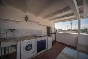 una cucina con lavatrice e un balcone di Sui tetti di Trani Harbour suite a Trani