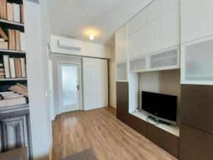 een woonkamer met een flatscreen-tv en een kamer met een open haard bij Sui Canali in Livorno