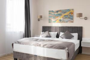 a bedroom with a large bed with a painting on the wall at Salt Hill Premium Apartments in Egerszalók