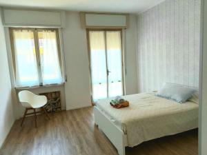 een slaapkamer met een bed met een stoel en ramen bij Sui Canali in Livorno
